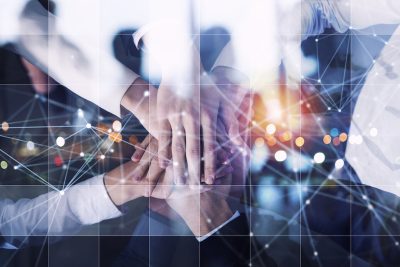 A team huddle with many hands coming together & virtual dots connecting in the backdrop showing ERP integration in E-commerce business