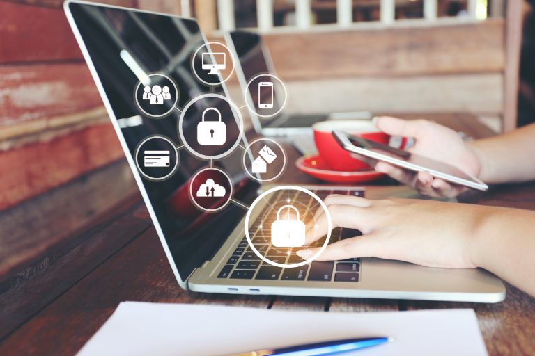 A person checking their website security on the laptop and mobile, image shows various elements that need to be secured