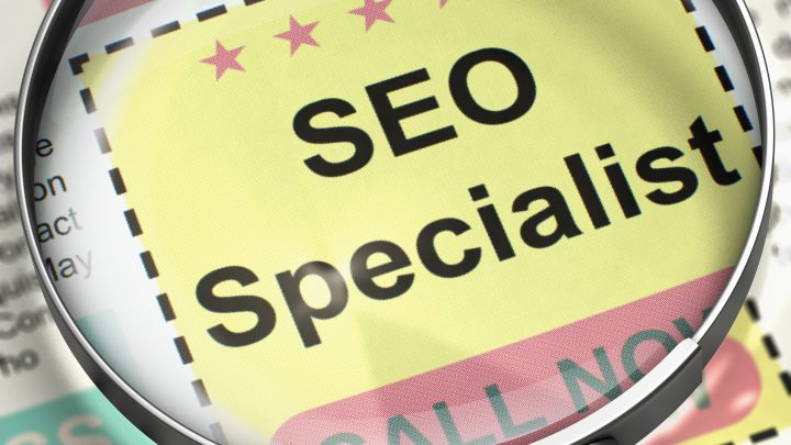 A magnifying glass focusing on an AD for SEO Specialist. SEO specialist.