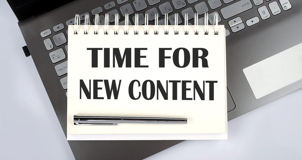 keyboard with a writing pad placed over it. Time for new content. Professional content writing services.