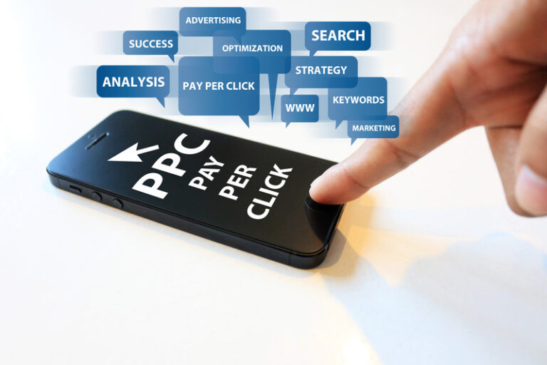 PPC specialist checking mobile phone.Display shows PPC - Pay per click. PPC agency terms like advertising, Search, Strategy, keywords, analysis