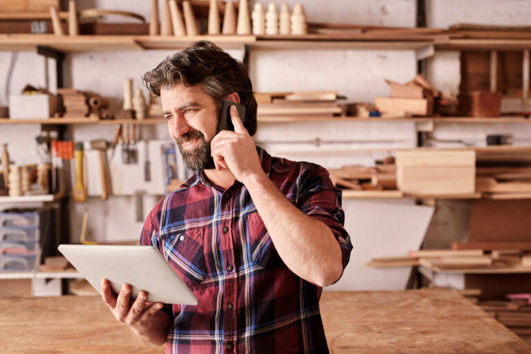 Small business owner talking on mobile and holding a tablet. showing impact of digital advertising for small businesses.